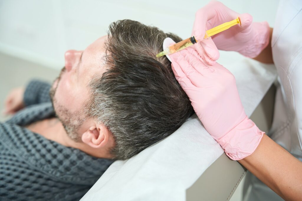 Cosmetologist performs a plasma-lifting procedure in the scalp