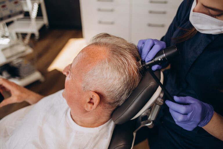 an old man is being examined by a trichologist
